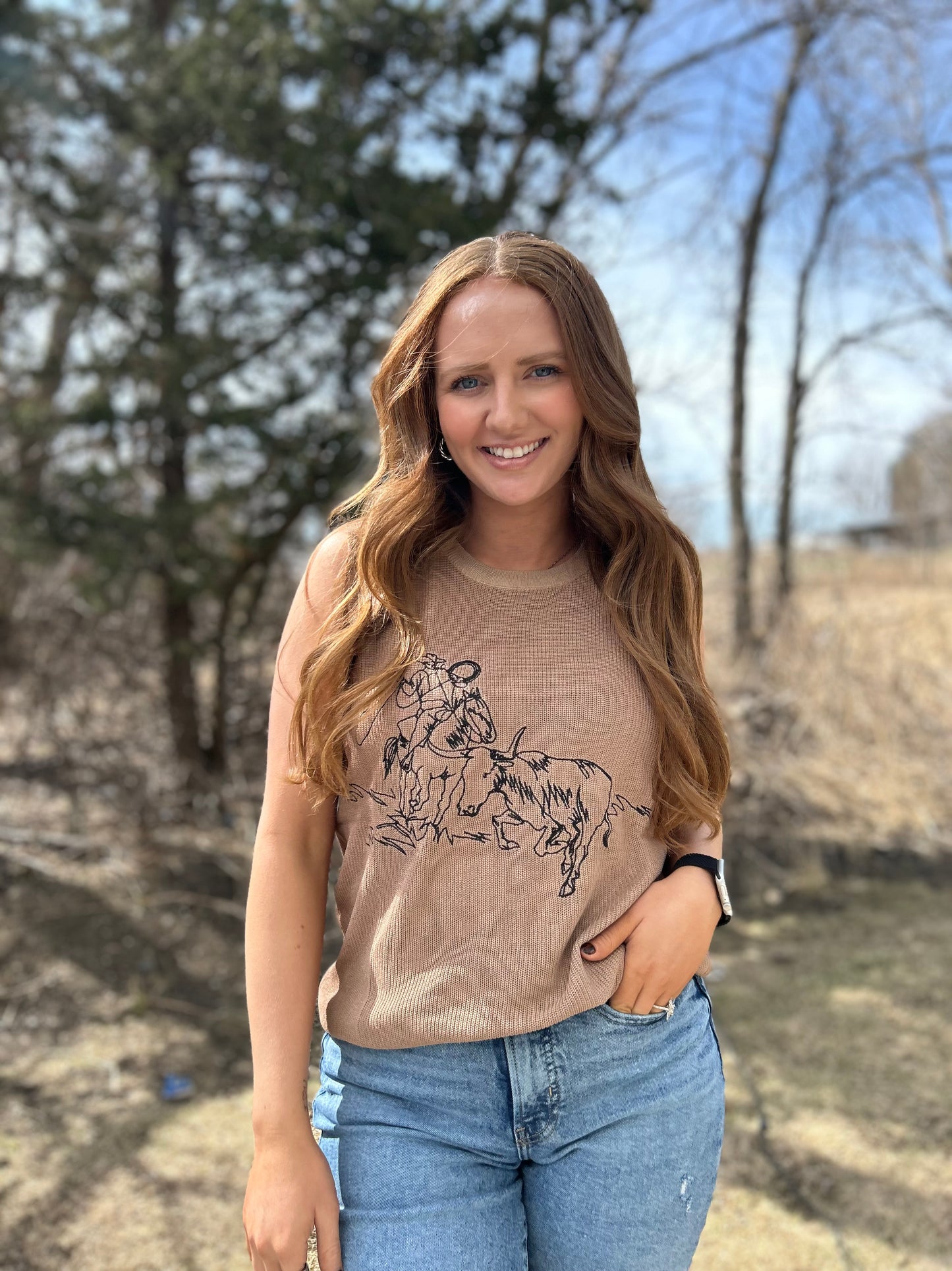 Woman wearing Stampede tank top with bold Western graphic