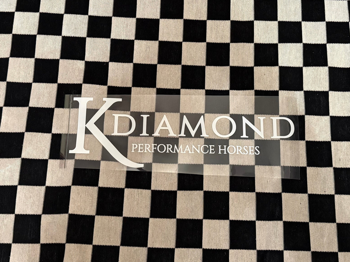 Black and white checkered towel with 'K Diamond' branding on a textured surface